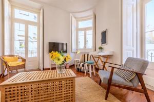 ein Wohnzimmer mit einer Blumenvase auf dem Tisch in der Unterkunft Spacious and elegant family home - BP1 in Lissabon