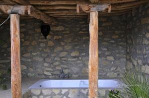 bañera frente a una pared de piedra en Les Terrasses de l'Atlas, en Imoulass