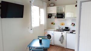 una pequeña cocina con mesa y fregadero en Sonella Bungalow, en Le Gosier