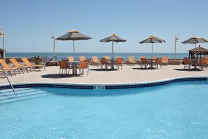 una piscina con sillas, mesas y sombrillas en Boardwalk Resorts at Atlantic Palace en Atlantic City
