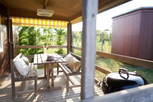 a wooden porch with a table and a bench on it at Camping Lido in Bibione