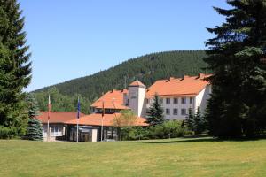 a large white building with a red roof at Waldhotel Berghof in Luisenthal