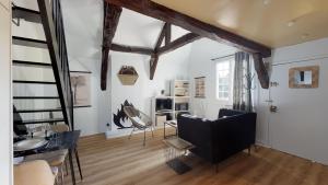 a living room with white walls and wooden beams at Breizh Cocon by Cocoonr in Rennes