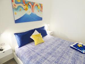 een slaapkamer met een bed met blauwe en gele kussens bij B&B Lemon Flats in Napels