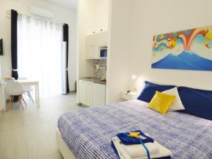 een slaapkamer met een blauw en wit bed en een keuken bij B&B Lemon Flats in Napels