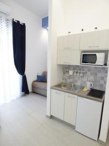 een keuken met witte kasten en een magnetron bij B&B Lemon Flats in Napels