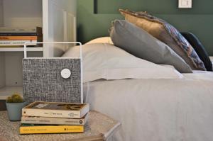 ein Bett mit Büchern auf einem Tisch neben einem Bett in der Unterkunft Casa Mysa - Apartment in Costa di Mezzate
