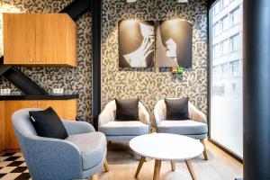 a living room with two chairs and a table at Hôtel Villa Eiffel Mademoiselle in Paris
