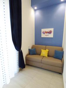 een bank in een kamer met een blauwe muur bij B&B Lemon Flats in Napels