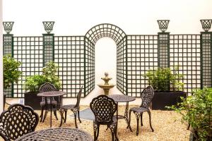 a patio with tables and chairs in front of a fence at Hôtel Villa Eiffel Mademoiselle in Paris