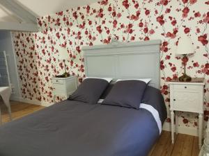a bedroom with a bed with red flowers on the wall at Le Dauphin in Chabeuil