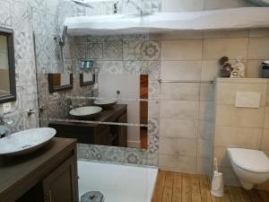 een badkamer met 2 wastafels en een toilet bij Le Dauphin in Chabeuil