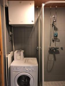 uma pequena casa de banho com uma máquina de lavar roupa e um chuveiro em Karhunvartijan Kartano 3 B 1, Rukan keskusta em Ruka