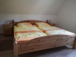 um quarto com uma cama de madeira e 2 almofadas em Ferienhaus Moorhof em Schneverdingen