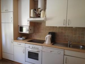 a kitchen with white cabinets and a sink at Ferienhaus Moorhof in Schneverdingen