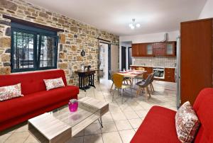 salon z czerwoną kanapą i ceglaną ścianą w obiekcie Villa Lato - Villa with private pool and yard w mieście Anatolí