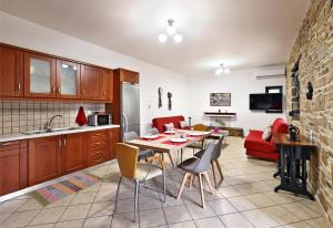 a kitchen and living room with a table and chairs at Villa Lato - Villa with private pool and yard in Anatolí