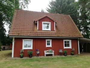 uma casa vermelha com uma mesa e cadeiras em frente em Ferienhaus Moorhof em Schneverdingen