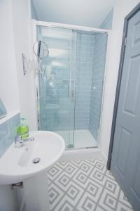 a bathroom with a sink and a glass shower at Air Host and Stay - Apartment 4 Broadhurst Court sleeps 4 minutes from town centre in Stockport