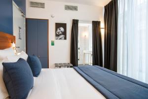 a bedroom with a large bed with blue pillows at Hôtel Villa Eiffel Mademoiselle in Paris