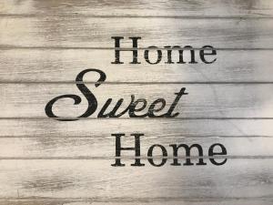 a sign with the words home sweet home on a wooden table at House Maximo at Colosseum in Rome