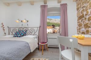 a bedroom with a bed and a desk and a window at Booba Rooms in Dubrovnik