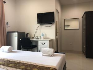 a room with two beds and a desk and a television at Khao Oat airport in Nai Yang Beach