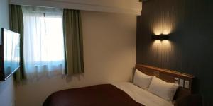 Postel nebo postele na pokoji v ubytování Ueno First City Hotel