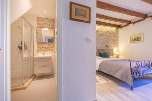 a bedroom with a bed and a shower and a sink at Booba Rooms in Dubrovnik