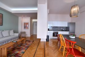 Una sala de estar con un sofá, una mesa y sillas. en Kolonaki Boutique Apartments by Olala Homes, en Atenas
