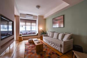 a living room with a couch and a tv at Kolonaki Boutique Apartments by Olala Homes in Athens