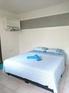 a bedroom with a bed with a blue spoon on it at Hostel Pigally in Goiânia