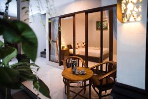 a room with a table and chairs and a bed at Suntari Homestay in Ubud