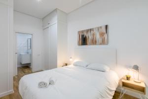 ein weißes Schlafzimmer mit einem großen Bett und einem Badezimmer in der Unterkunft Loft Candela in Sevilla