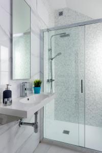 a bathroom with a glass shower and a sink at Apartamentos Adriano in Seville