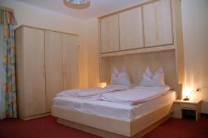 een slaapkamer met een bed met witte lakens en kussens bij Gästehaus Golker in Bad Gastein