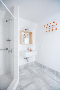 baño blanco con ducha y lavamanos en The Hamlet Inn, en Solvang