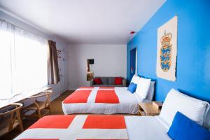 two beds in a room with blue and red at The Hamlet Inn in Solvang