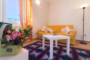 a living room with a yellow couch and a table at Appartamento di Bianca C. in Assisi