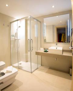 uma casa de banho com um chuveiro, um WC e um lavatório. em Hotel Plaza De La Paz em Haro
