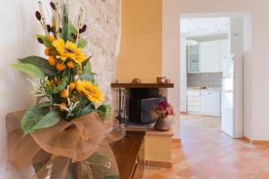 um vaso cheio de flores amarelas numa cozinha em Appartamento di Bianca C. em Assis