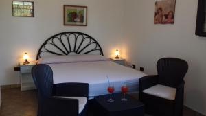 - une chambre avec un lit et deux verres de vin dans l'établissement Otranto Le Sancinare, à Casamassella