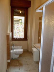 ein Bad mit einem WC, einem Waschbecken und einem Fenster in der Unterkunft Casa Grazia in Lovero Valtellino