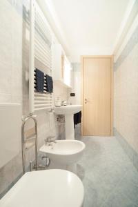 La salle de bains blanche est pourvue d'un lavabo et de toilettes. dans l'établissement IRIS CENTRALISSIMO, à Sanremo