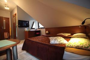 a bedroom with a large bed with two pillows at Gościnny Dworek in Pobierowo