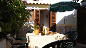 una mesa con un mantel blanco y una sombrilla en Family house Adraga, en Sintra