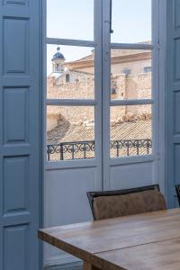 une table et une fenêtre avec vue sur un bâtiment dans l'établissement Casa Luz - 5 minutos andando de la playa, à Alicante