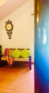 a bench in a room with a clock on the wall at Urban Retreat Homestay in Mangalore