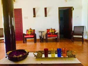 una sala de estar con sillas y una bandeja de comida en Urban Retreat Homestay, en Mangalore