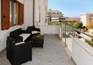 a balcony with two chairs and a table at Alkira Lodge - Via Txu Terrat in Alghero